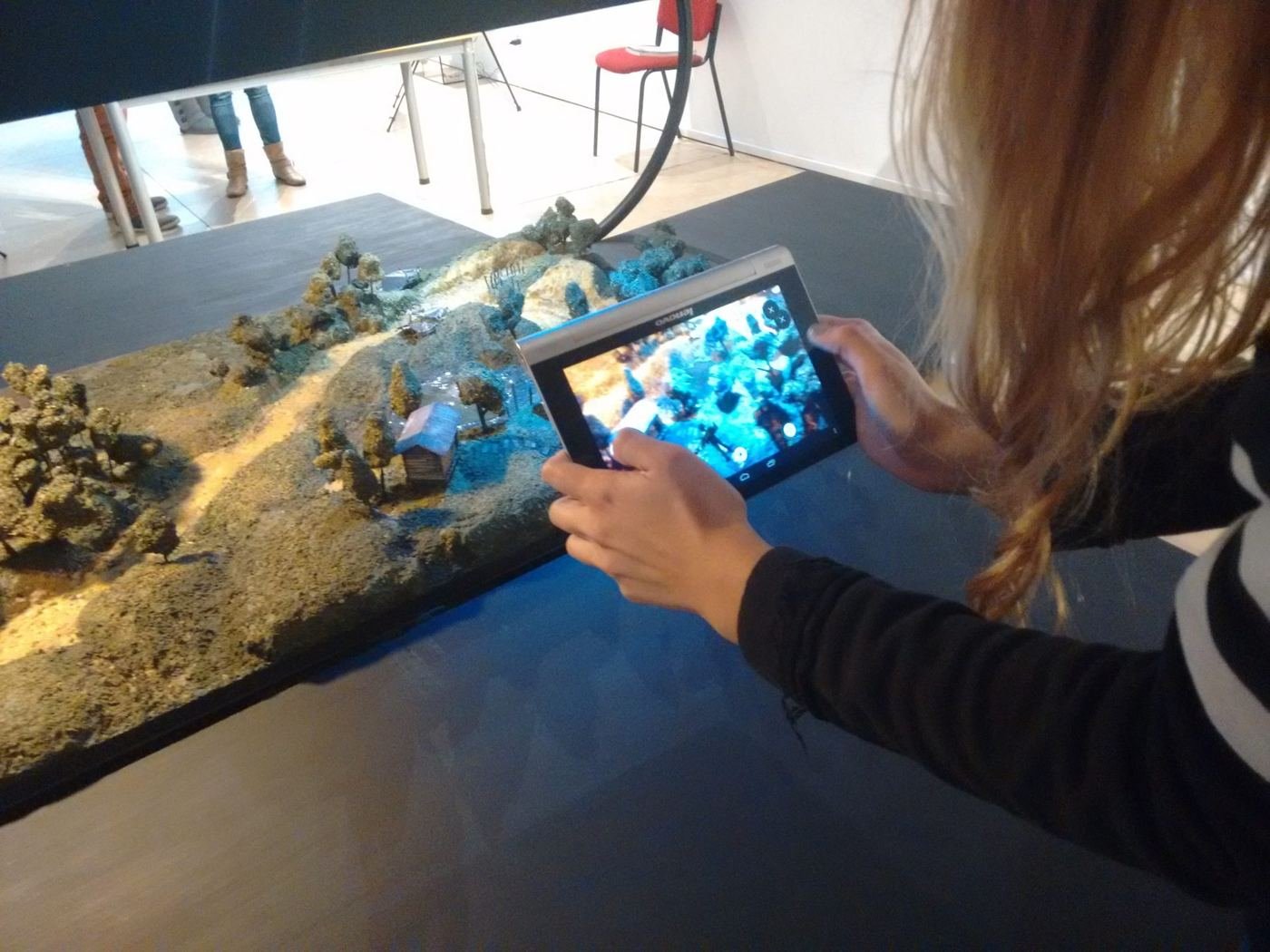 Una visitante recorre con una tableta la maqueta de 4 Ríos en realidad aumentada