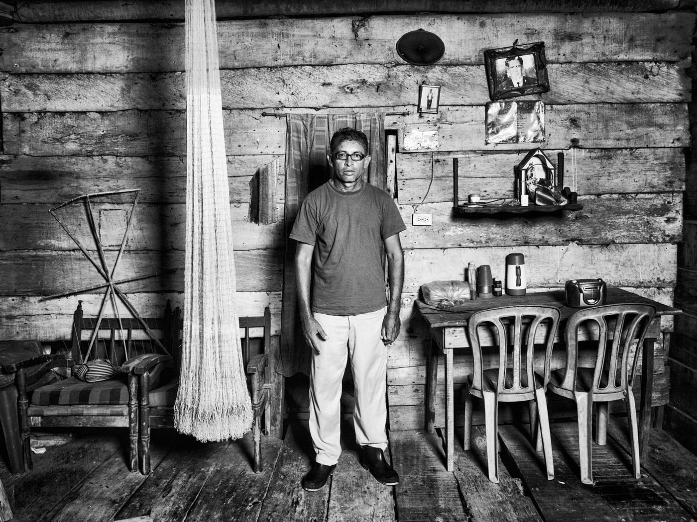 Un pescador de pie dentro de su casa de madera. Foto: Jorge Panchoaga