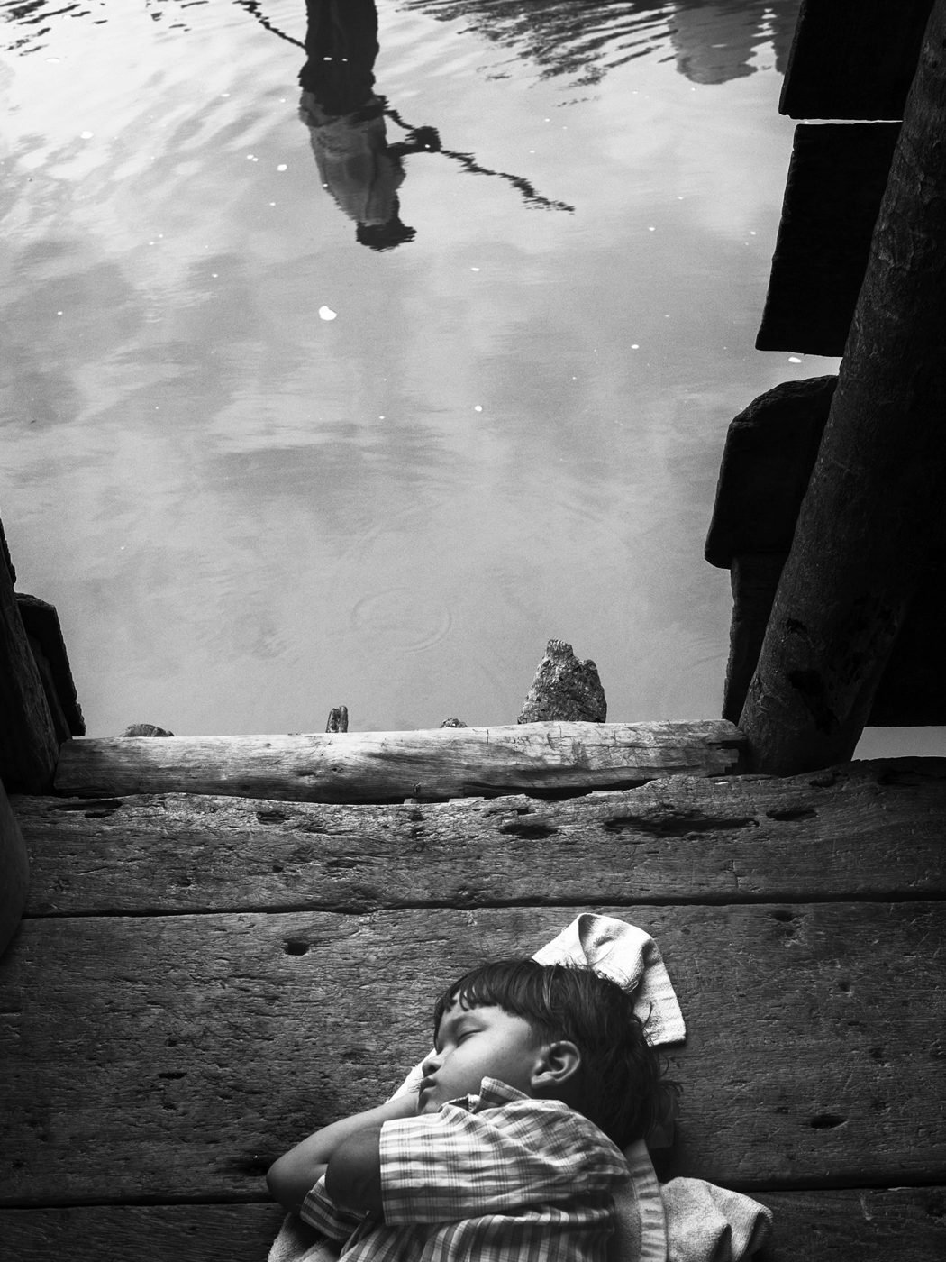 Una niña duerme sobre las tablas de una casa palafítica. Foto: Jorge Panchoaga
